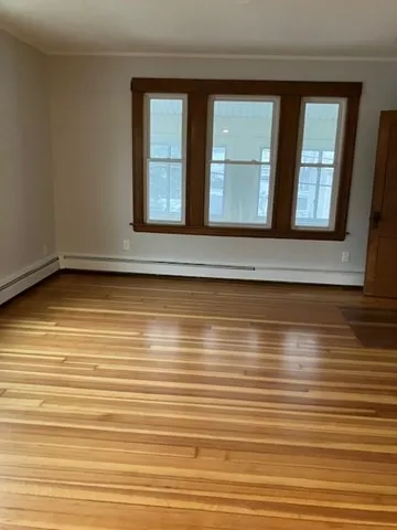a view of a room with wooden floor and window