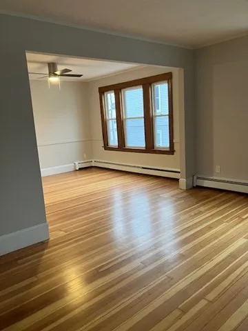 a view of a room with wooden floor and a window