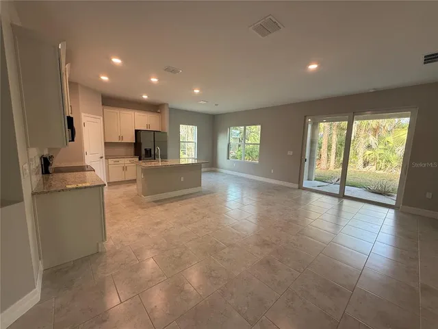 a view of a kitchen with refrigerator and windows