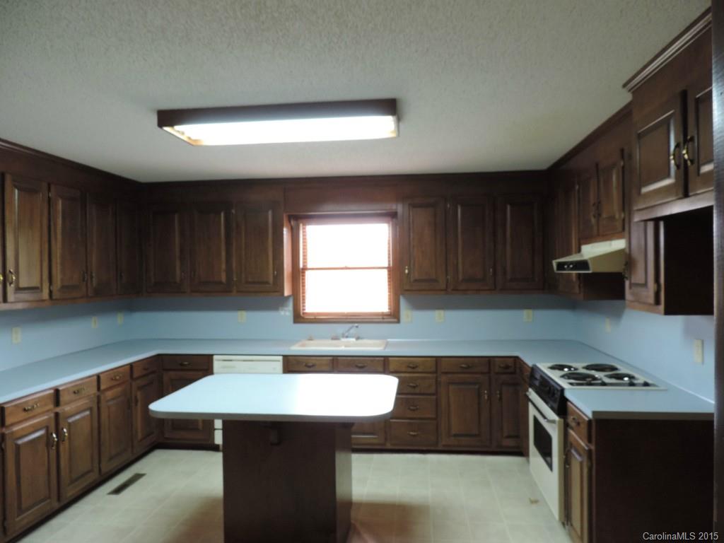 225 Woodridge Road Mooresville, NC 28115 - Photo 8 of 23 a kitchen with a sink a stove a refrigerator and cabinets