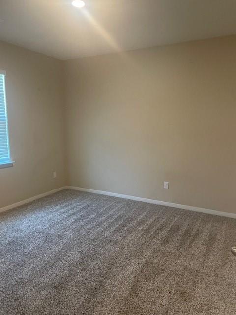 205 Lake Ridge Princeton, TX 75407 - Photo 12 of 13 Spare room featuring dark colored carpet and baseboards