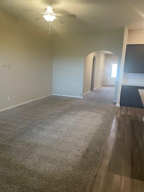 205 Lake Ridge Princeton, TX 75407 - Photo 7 of 13 Unfurnished room with arched walkways, ceiling fan, and dark wood-style floors