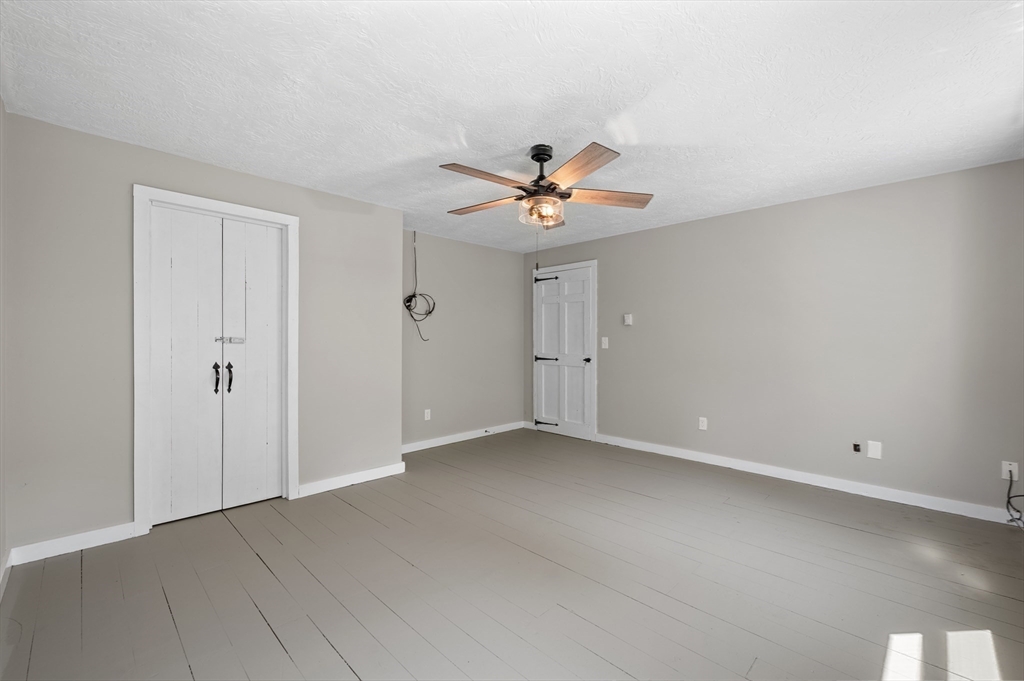 254 Adams Road Oakham, MA 01068 - Photo 12 of 29 an empty room with a ceiling fan and a window