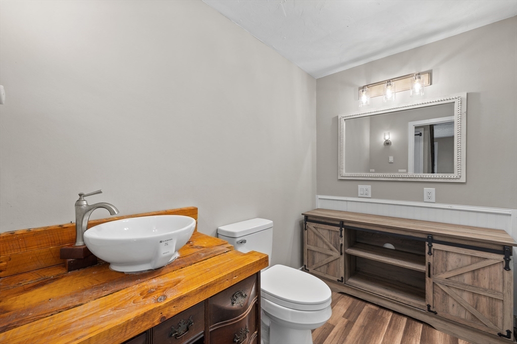 254 Adams Road Oakham, MA 01068 - Photo 18 of 29 a bathroom with a granite countertop toilet sink and mirror