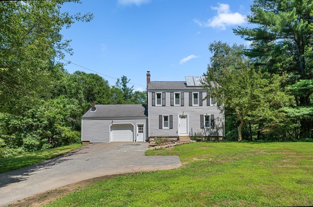 254 Adams Road Oakham, MA 01068 - Photo 25 of 29 a front view of a house with a yard and trees