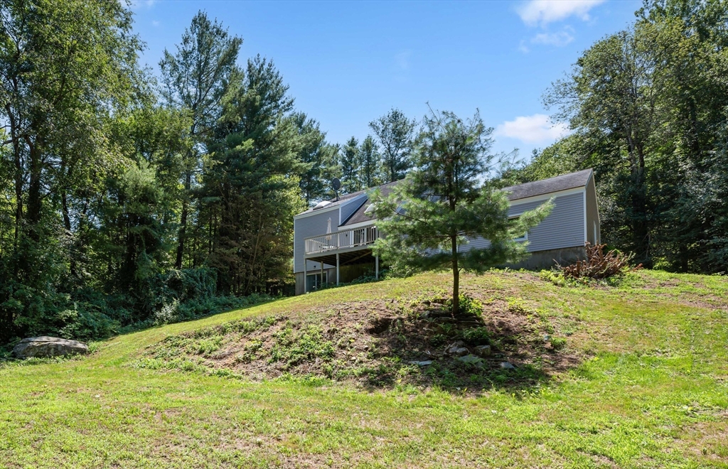 254 Adams Road Oakham, MA 01068 - Photo 27 of 29 a house is sitting in middle of the green field