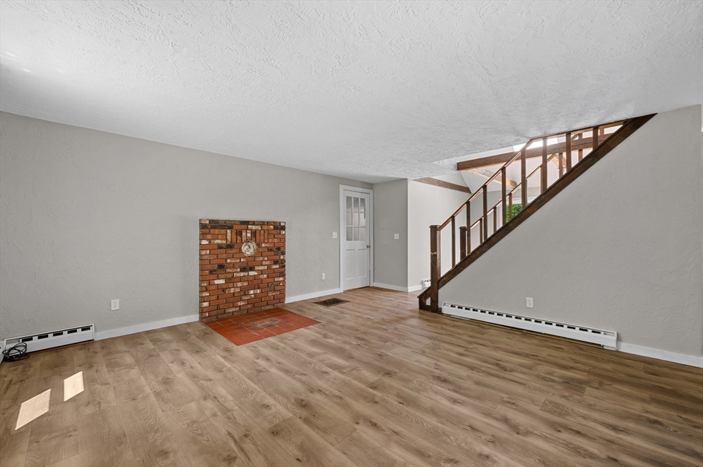 254 Adams Road Oakham, MA 01068 - Photo 3 of 29 a view of an empty room with wooden floor and stairs