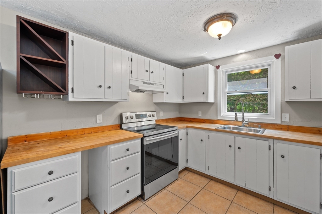 254 Adams Road Oakham, MA 01068 - Photo 9 of 29 a kitchen with white cabinets and white appliances