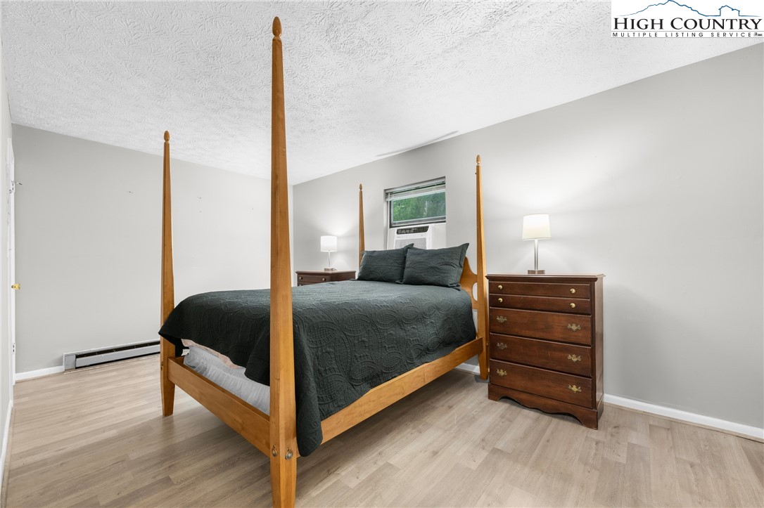 1469 West King Street, Unit 201 Boone, NC 28607 - Photo 13 of 19 a bedroom with a bed and wooden floor
