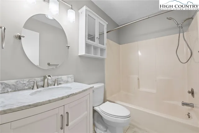 a bathroom with a granite countertop sink a toilet and a bathtub