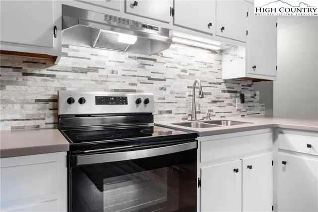 a stove top oven sitting inside of a kitchen