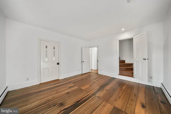 a view of empty room with wooden floor and fireplace