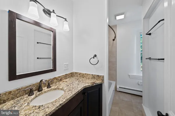 a bathroom with a granite countertop sink vanity granite and a mirror