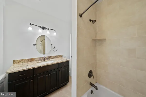 a bathroom with a granite countertop sink a mirror and a shower