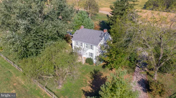 a view of house with yard and trees in the background