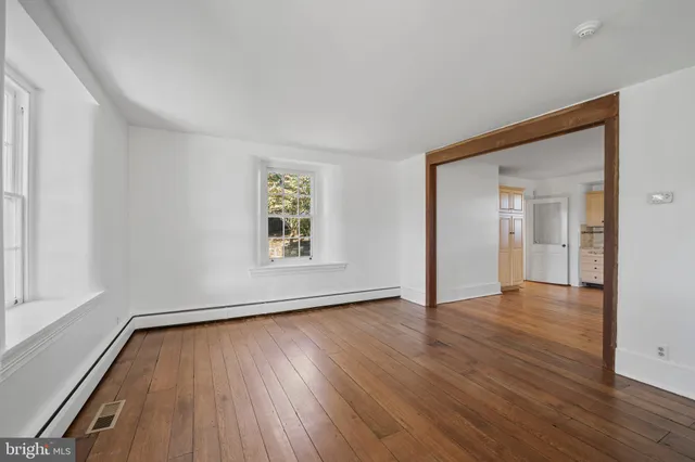 wooden floor in an empty room with a window