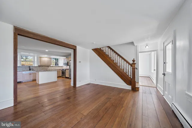 a view of a hallway with wooden floor kitchen view and a faucet