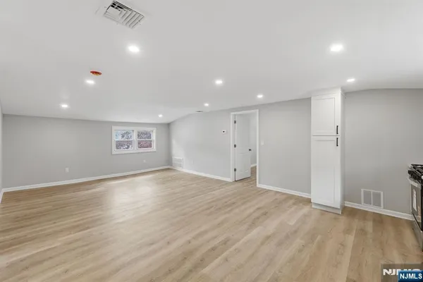 a view of an empty room with wooden floor