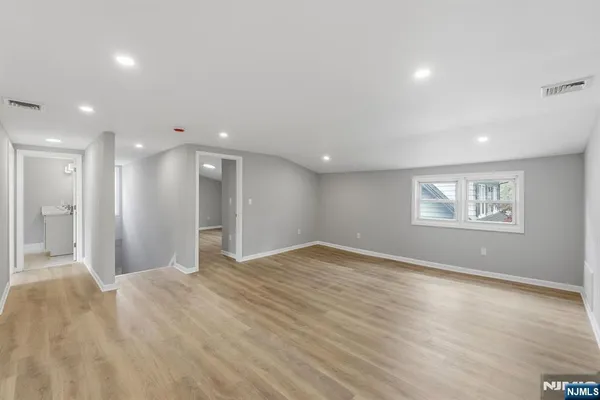 a view of empty room with wooden floor