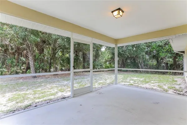 a view of empty room with floor to ceiling window and tree