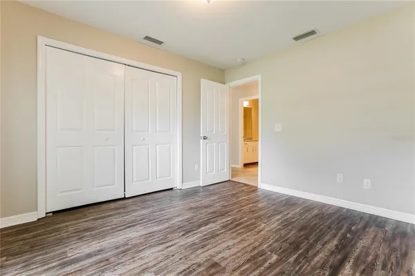 a view of an empty room with wooden floor