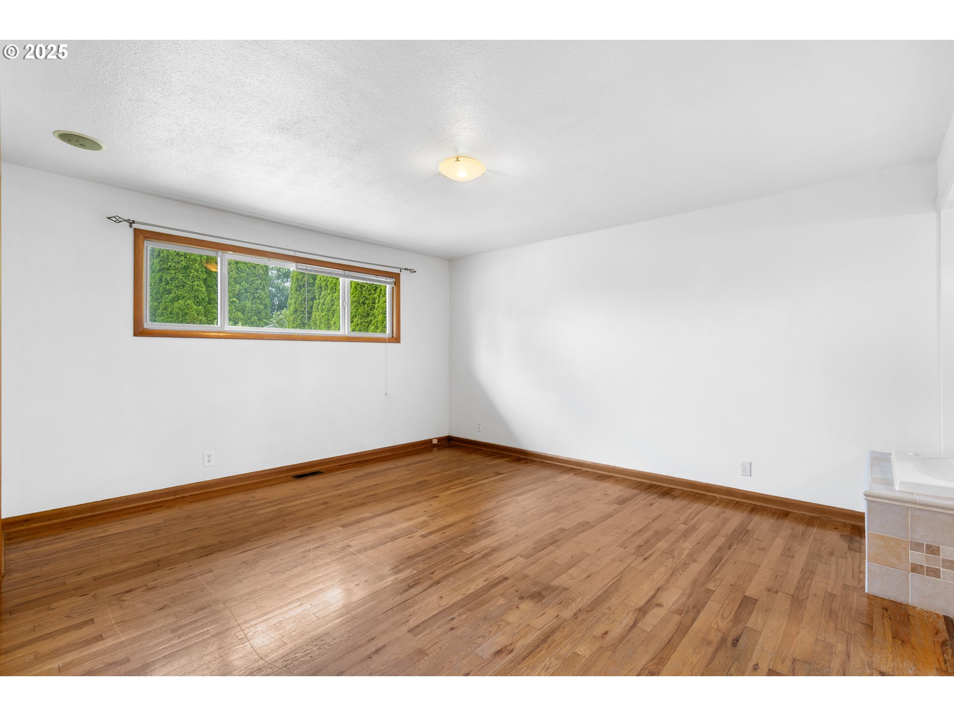 1897 Chelan Street Northeast Keizer, OR 97303 - Photo 15 of 39 a view of an empty room with wooden floor and a window