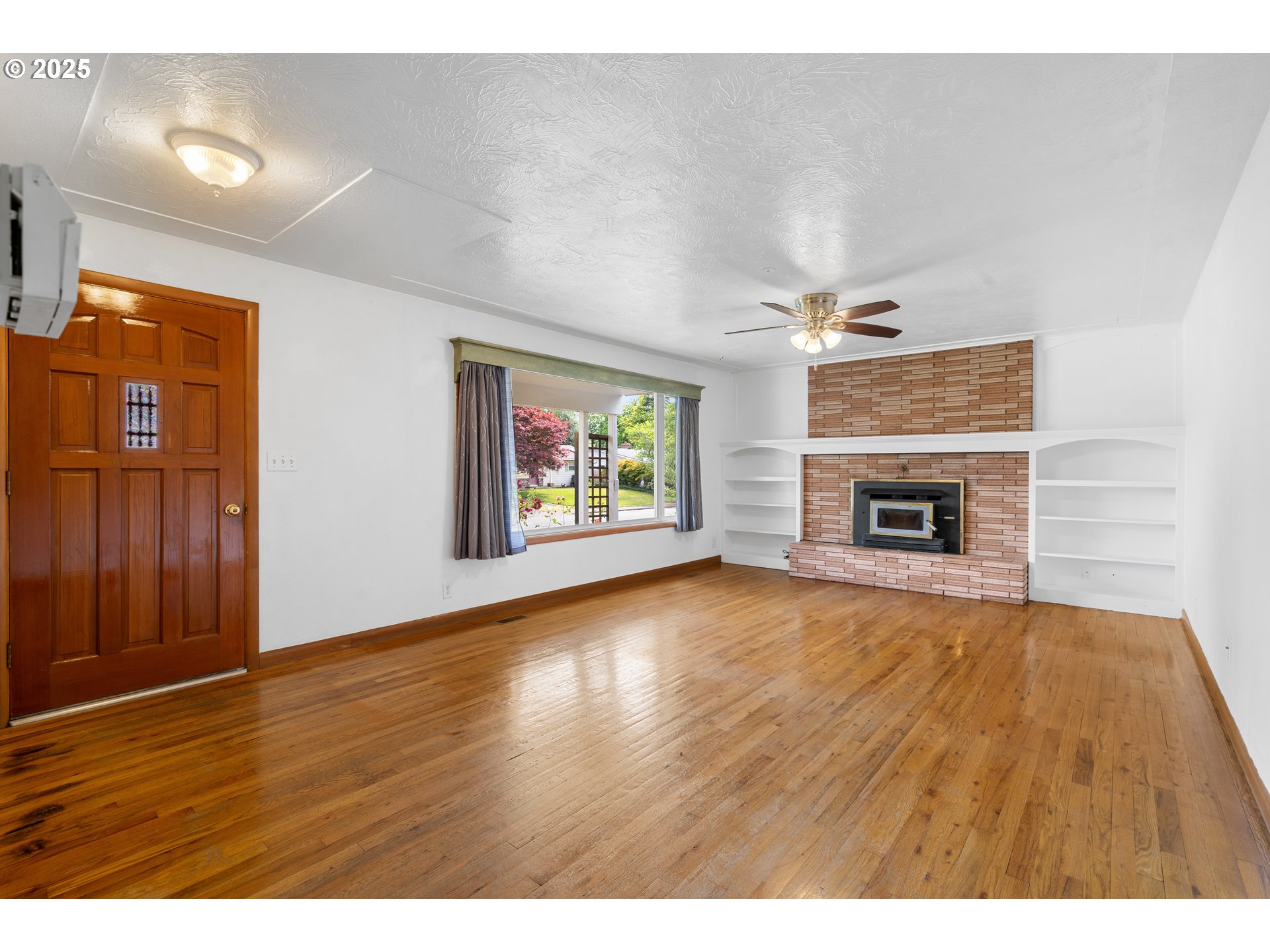 1897 Chelan Street Northeast Keizer, OR 97303 - Photo 5 of 39 a view of an empty room with wooden floor fireplace and a window