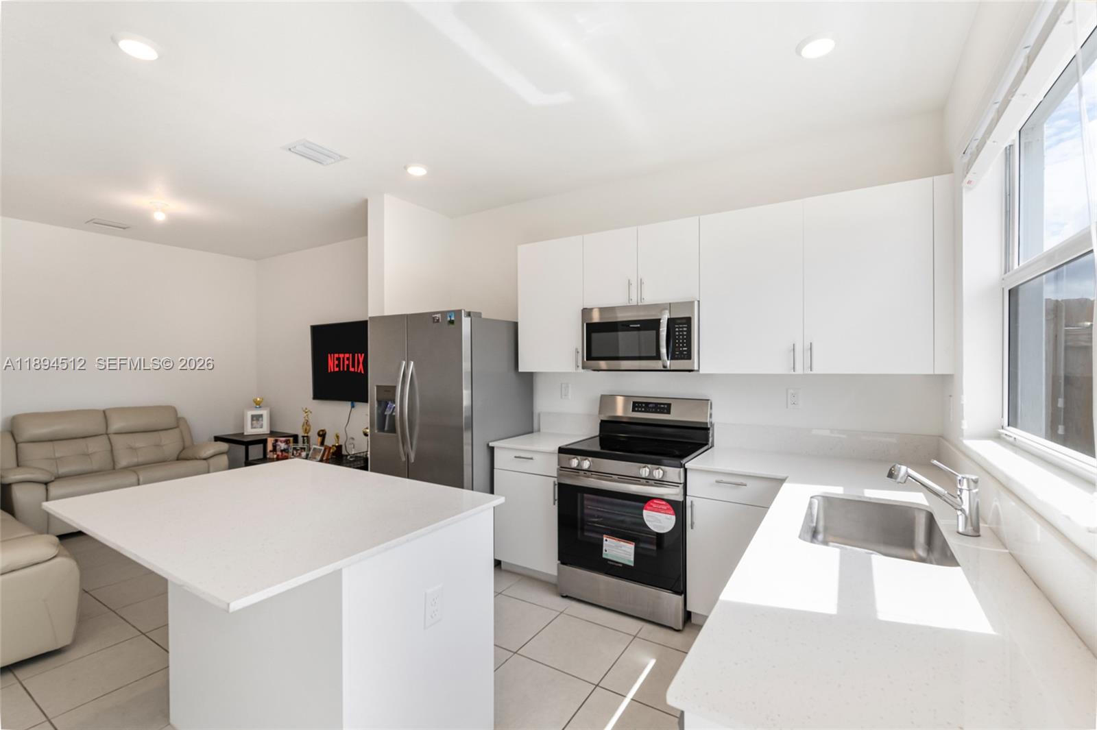 29254 Southwest 163rd Court Homestead, FL 33033 - Photo 2 of 29 a kitchen with stainless steel appliances a stove a sink a microwave and cabinets