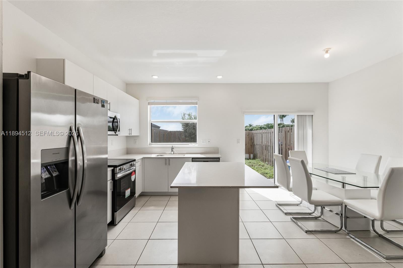 29254 Southwest 163rd Court Homestead, FL 33033 - Photo 6 of 29 a large kitchen with kitchen island granite countertop a large counter top space appliances and cabinets