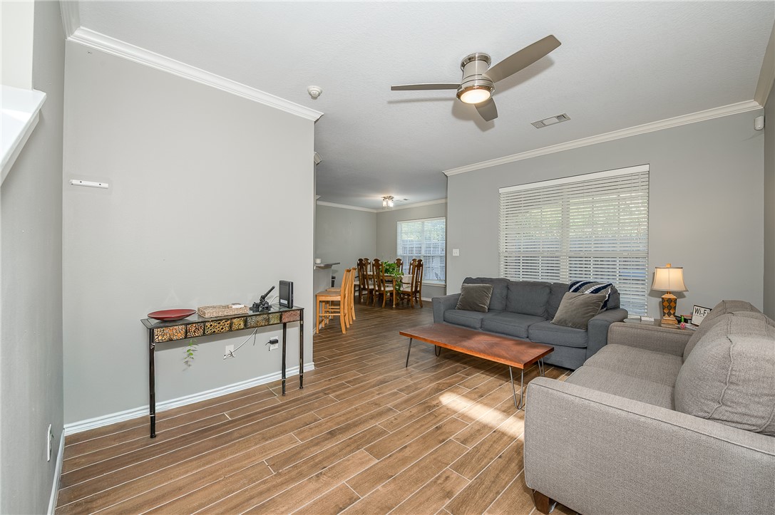 1425 West Villa Maria Road, Unit 103 Bryan, TX 77801 - Photo 3 of 30 Living area with ornamental molding, wood finish floors, and ceiling fan