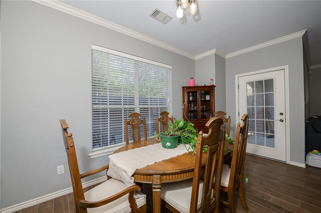 1425 West Villa Maria Road, Unit 103 Bryan, TX 77801 - Photo 6 of 30 Dining room featuring dark wood-style flooring and crown molding