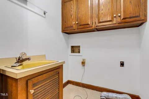 an empty room with chandelier fan and windows