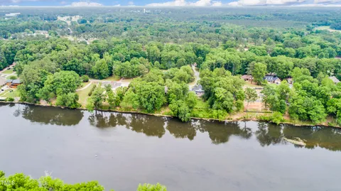 an aerial view of residential houses with outdoor space and lake view