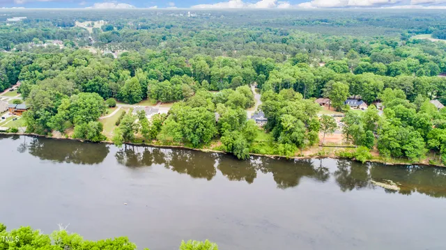 an aerial view of residential houses with outdoor space and lake view