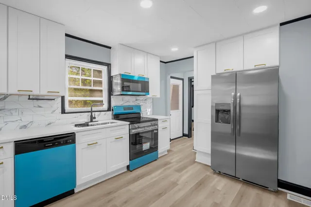 a kitchen with stainless steel appliances white cabinets and a stove top oven