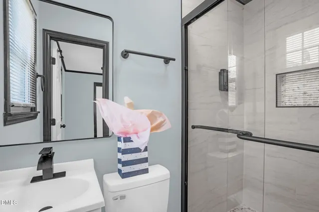 an empty room with wooden floor chandelier fan and windows