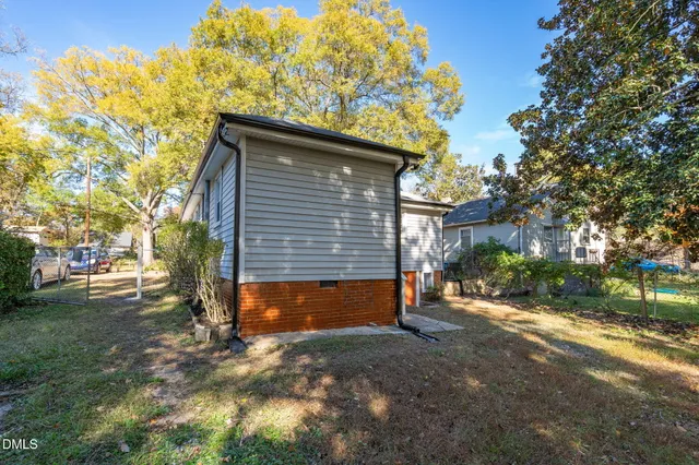 a view of a yard with plants and trees