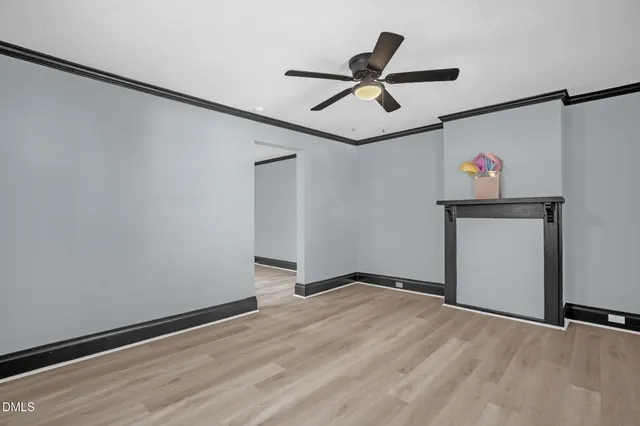 an empty room with windows and ceiling fan