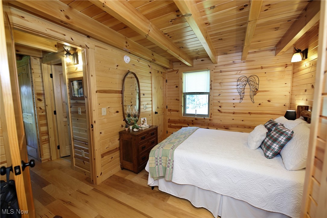 1313 Arner Road Chester, WV 26034 - Photo 28 of 46 Bedroom with wood finished floors, wood walls, and a wooden ceiling with exposed beams