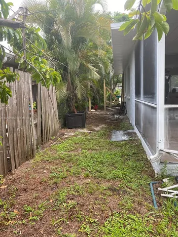 a view of a yard with plants and trees