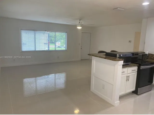 a kitchen with granite countertop white cabinets and white appliances