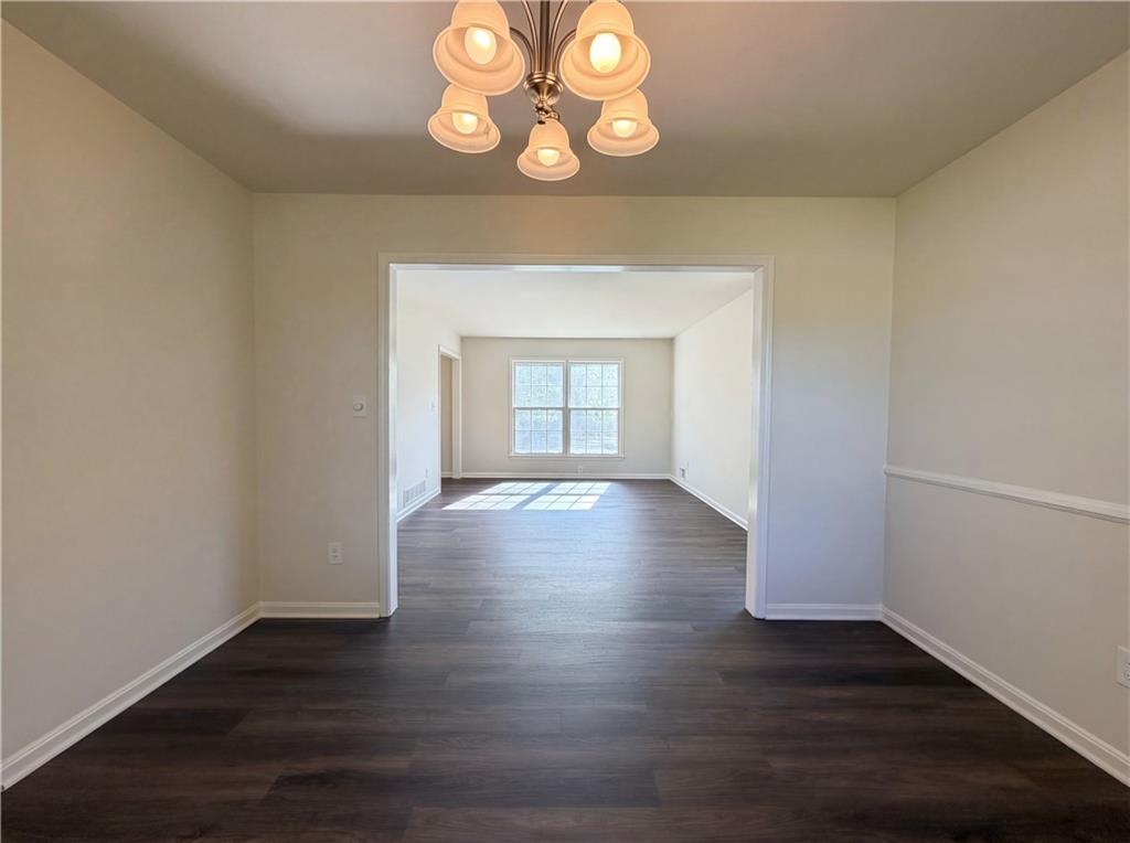 4055 Tecumseh Trail Conley, GA 30288 - Photo 13 of 30 an empty room with wooden floor and windows