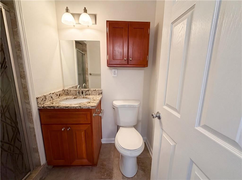 4055 Tecumseh Trail Conley, GA 30288 - Photo 20 of 30 a bathroom with a granite countertop toilet sink and mirror