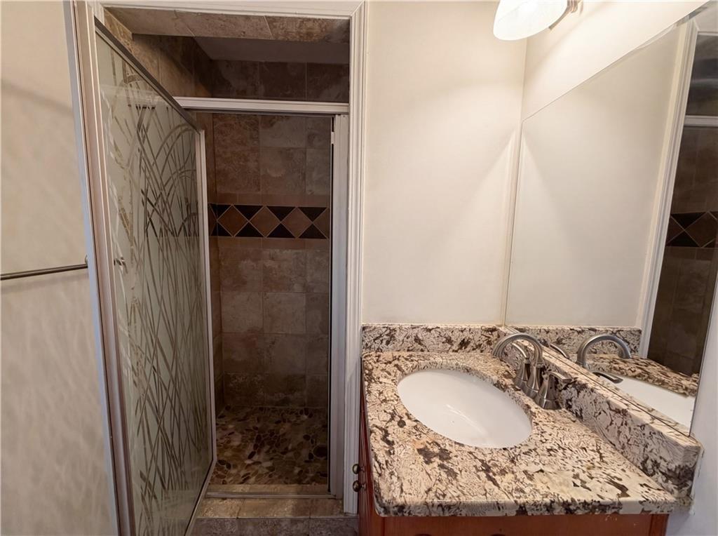 4055 Tecumseh Trail Conley, GA 30288 - Photo 21 of 30 a bathroom with a granite countertop sink and a mirror