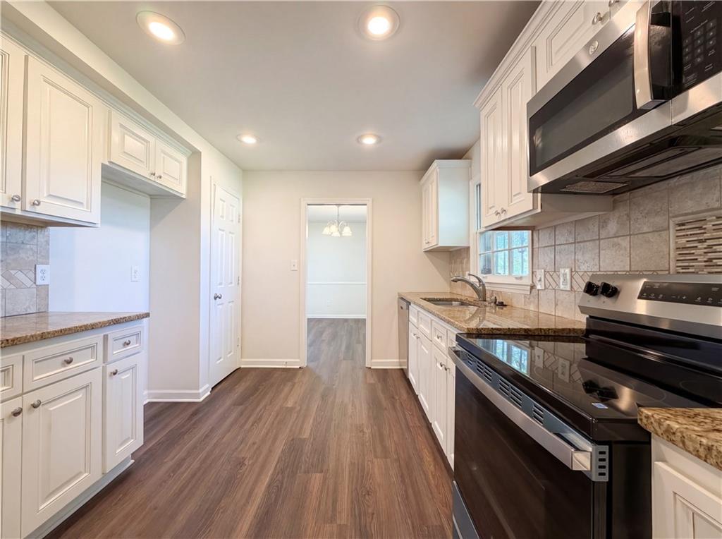 4055 Tecumseh Trail Conley, GA 30288 - Photo 8 of 30 a kitchen with wooden floors and appliances