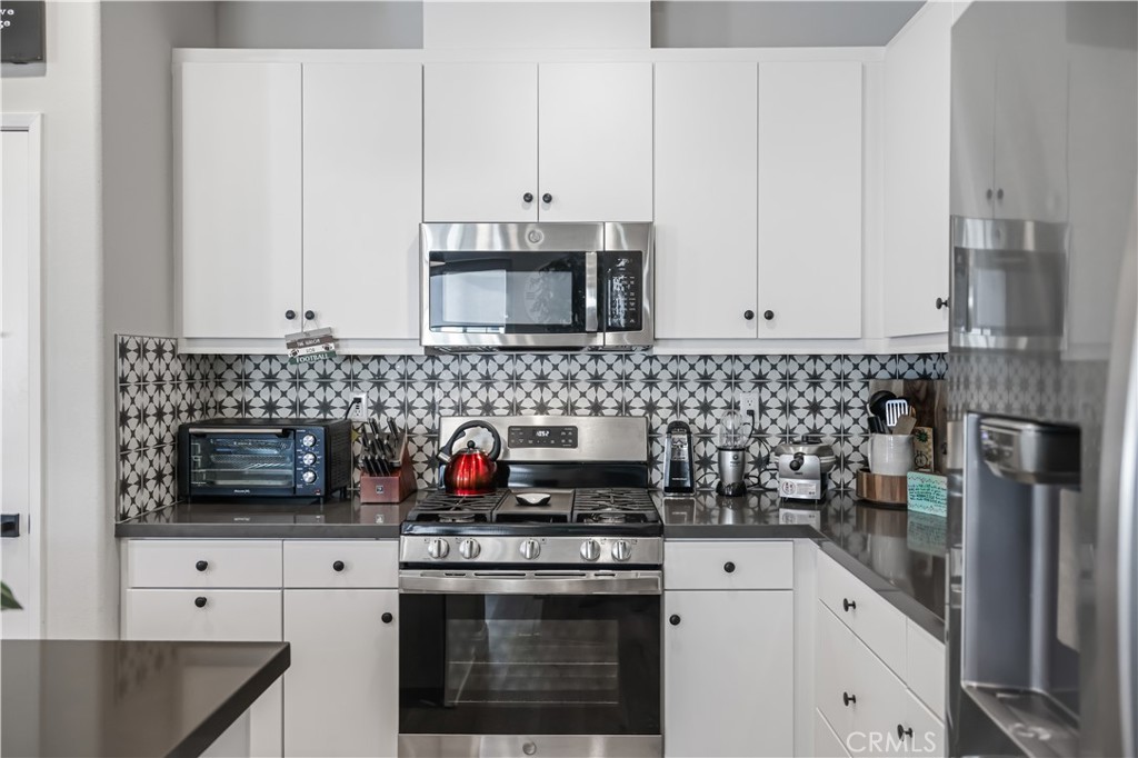 5604 Altamura Way, Unit 11 Fontana, CA 92336 - Photo 13 of 51 a kitchen with stainless steel appliances granite countertop white cabinets a stove a sink and dishwasher