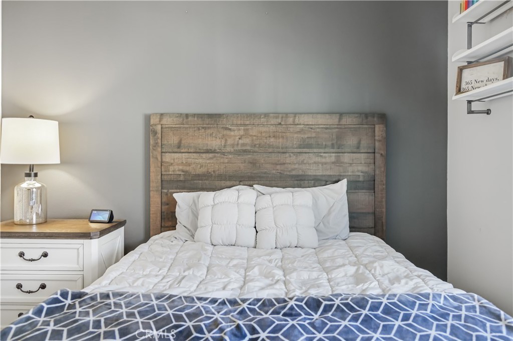 5604 Altamura Way, Unit 11 Fontana, CA 92336 - Photo 20 of 51 a bedroom with a bed and a lamp on dresser