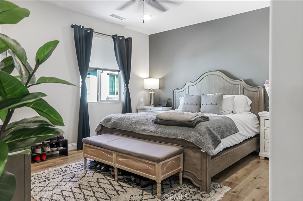 5604 Altamura Way, Unit 11 Fontana, CA 92336 - Photo 22 of 51 a bedroom with a bed lamp and a potted plant