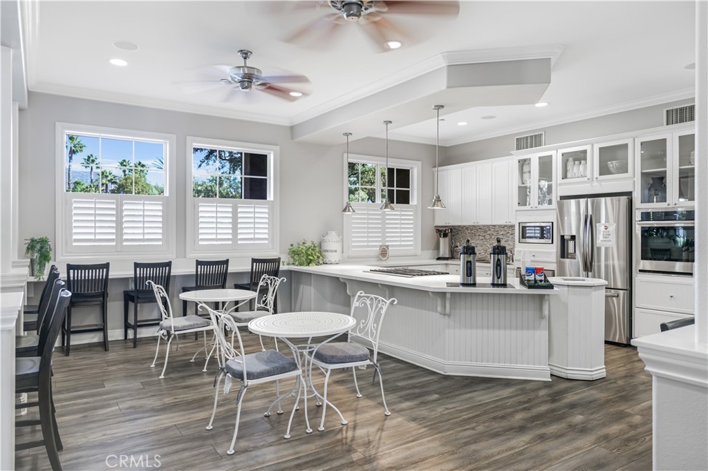 5604 Altamura Way, Unit 11 Fontana, CA 92336 - Photo 46 of 51 a kitchen with stainless steel appliances a dining table chairs and white cabinets