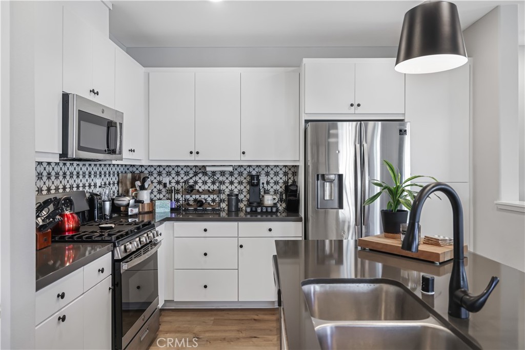 5604 Altamura Way, Unit 11 Fontana, CA 92336 - Photo 7 of 51 a kitchen with stainless steel appliances a sink a stove and cabinets